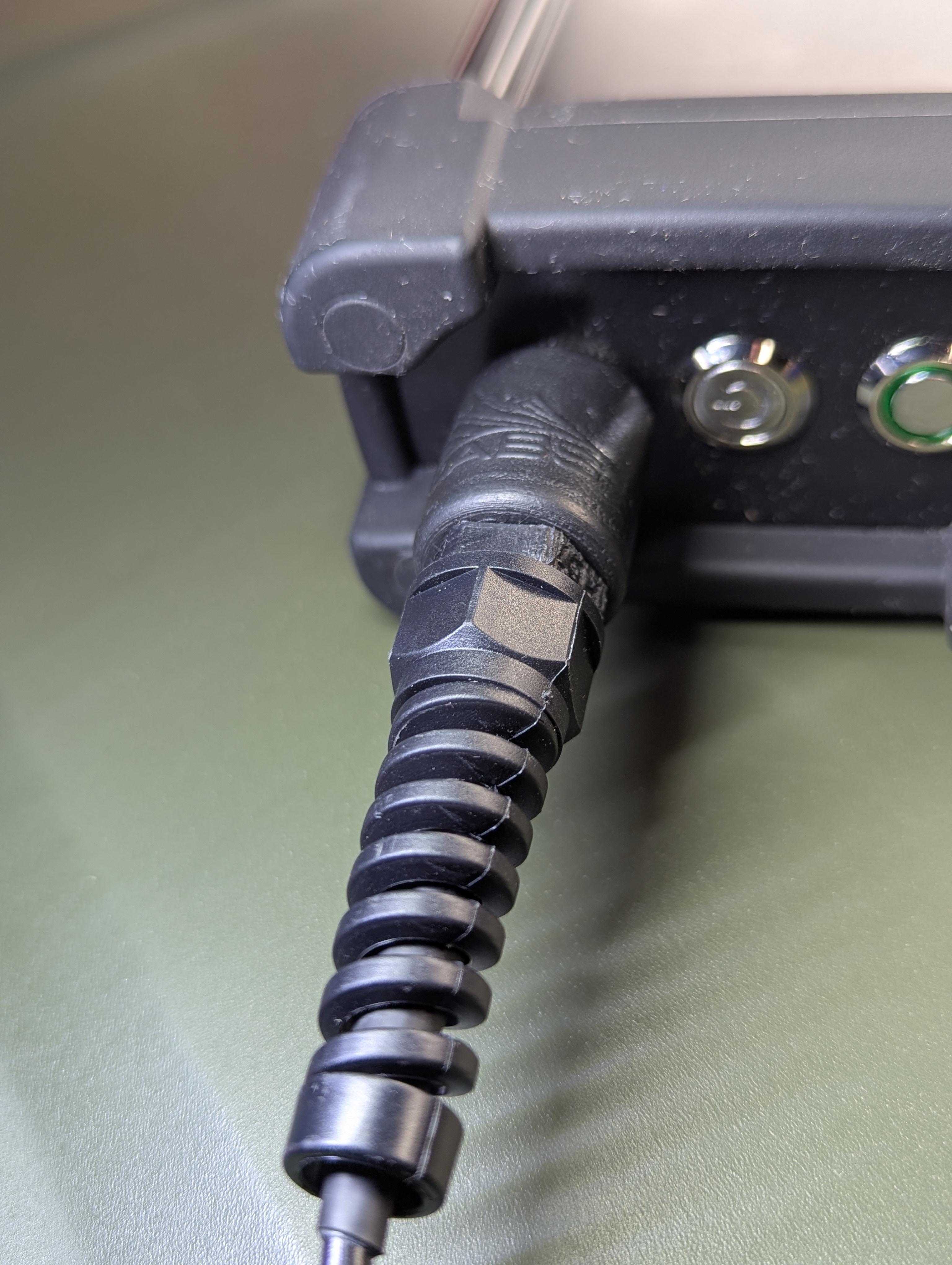 Close-up of the RC-2 charger's open 5.5 mm x 2.1 mm center-positive barrel socket mounted on an RM-1/RM-2 radio