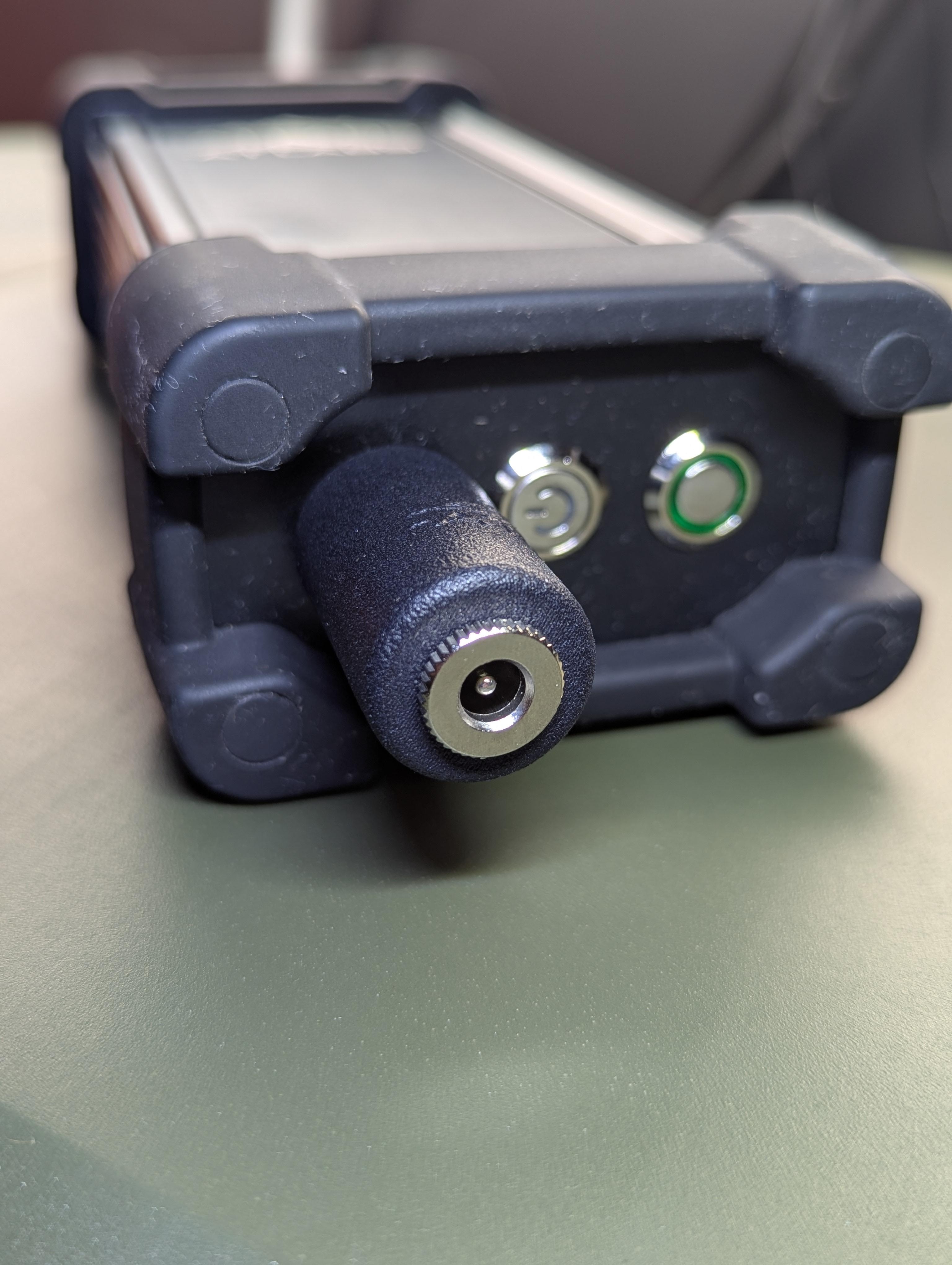 RC-2 charger attached to an AT Labs RM-1/RM-2 radio with the 12V DC barrel input open and ready for any in-spec power source